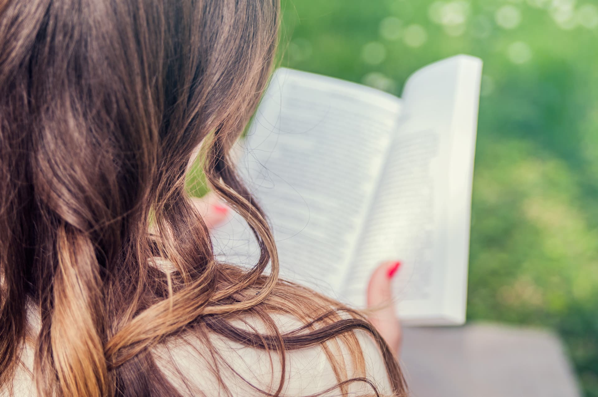 ragazza che legge libro al parco