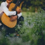 ragazzo con chitarra su un prato