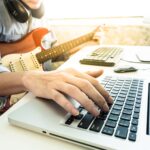 ragazzo che suona la chitarra e pc