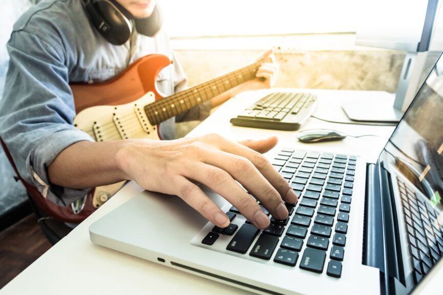 ragazzo che suona la chitarra e pc